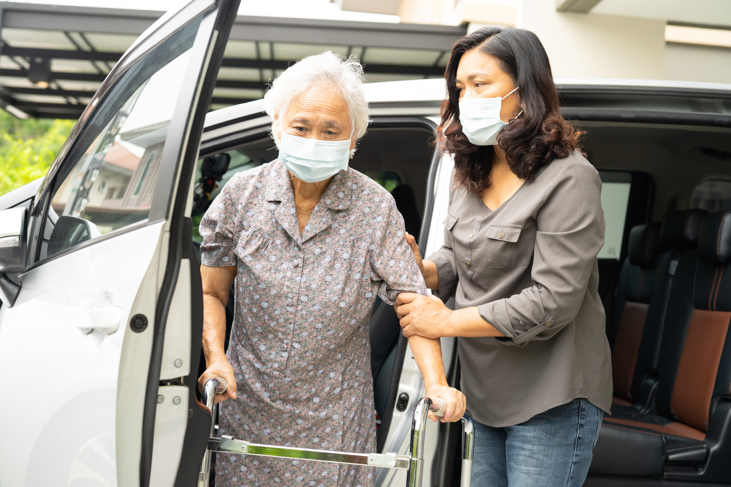 Transportation services for seniors Atlantis FL caregiver assisting elderly client into vehicle for safe home care transportation services Atlantis FL